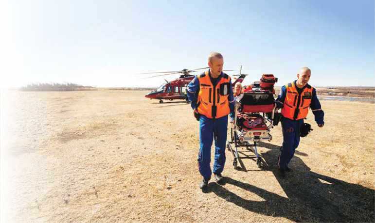Stars paramedics pulling stretcher from helicopter on sand Stars paramedics pulling stretcher from helicopter on sand