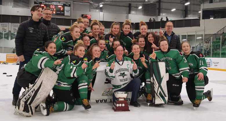 Saskatoon stars women's hockey team on ice wearing hockey equipment in front of a trophy Saskatoon stars women's hockey team on ice wearing hockey equipment in front of a trophy